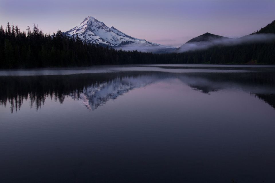 Un lac de montagne au crépuscule, le sommet reflété dans l'eau